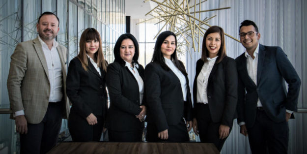 Retired Business Owner and Estate Planning Attorney Pose with Dedicated Employees