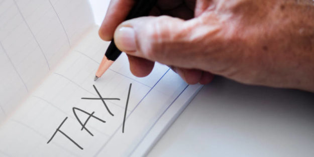 The Word "Tax" Written on a Piece of Paper, Hudack Law Estate Planning Attorney in Corona.