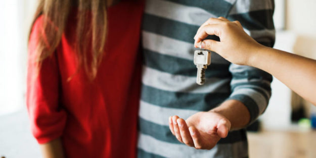 Landlord Giving Keys to New Rental Couple with Corona Estate Planning Attorney.