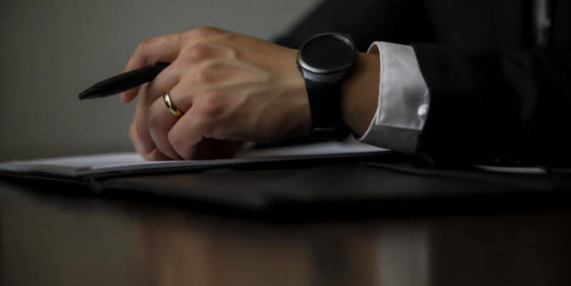 Corona Estate Planning Attorney Hand With a Pencil and a Book.