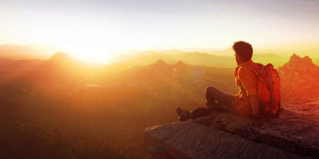 Young Traveler Staring at the Sunset at the Top of a Big Rock, Corona Estate Planning Attorney.