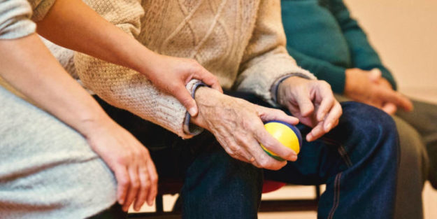 Elderly man holding a ball in his right hand and a woman holding his hand, Estate Planning Attorney.