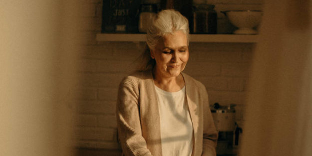 Elderly Woman with a smile at the kitchen finishing some cupcakes, Estate Planning Attorney.