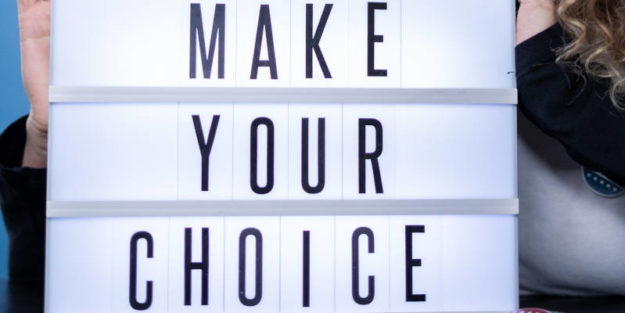 Woman Holding a Sign With White Lighting as Background That Says "Make Your Choice".