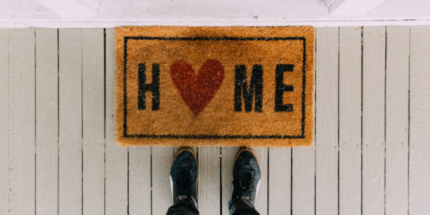 Feet of a Person in Front of a Rug With the Word Home on It, Estate Planning Attorney.