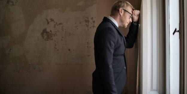 A Corona Estate Planning Attorney Standing Near the Window.