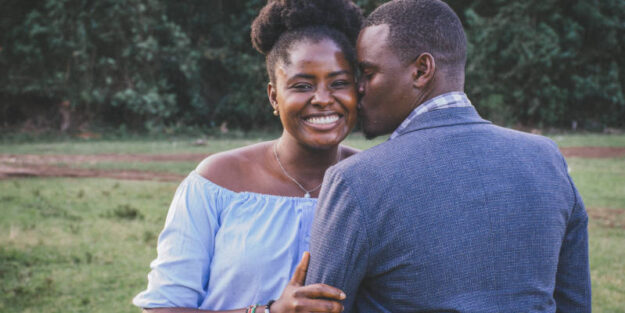 A Man Kissing Left Cheek of Smiling Woman, Corona Estate Planning Attorney.