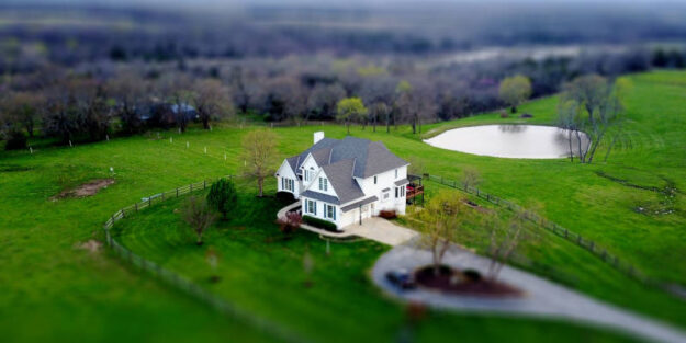 Top View of a Gray and White House on a Green Grass With a Little Lake at the Back, Corona Estate Planning Attorney.