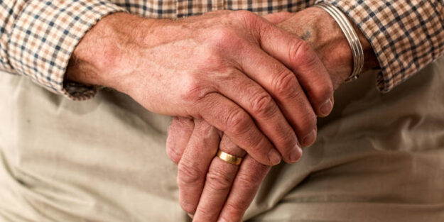 Hands of an Elderly Man Holding a Cane, Corona Estate Planning Attorney.