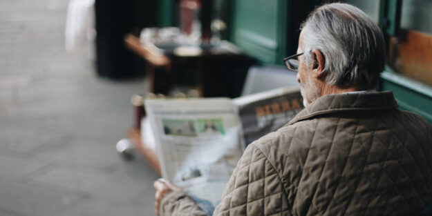 An Elderly Reading the Newspaper About Elder Law Attorneys.