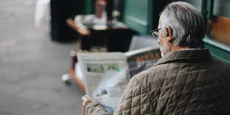 An Elderly Reading the Newspaper About Elder Law Attorneys.