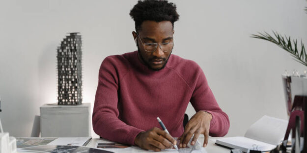 An African American Execute the Proper Estate Planning Documents on a Table at Corona Estate Planning Attorney.