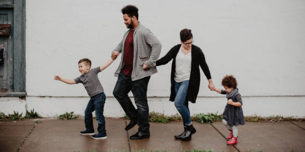 Two Kids, Mom And Dad Walking At The Street After A Rainy Day, Corona Estate Planning Attorney.
